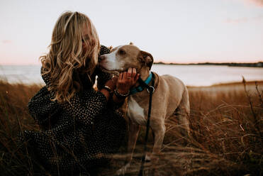 Frau und Hund am Strand bei Sonnenuntergang - CAVF67002