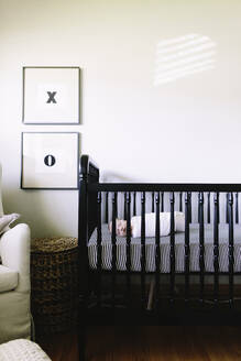 A baby boy sleeping in his crib in a modern nursery - CAVF67040