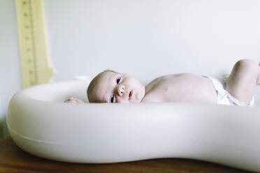 Side view of a newborn baby boy laying on a changing table - CAVF67046