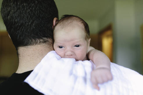 Over the should view of a first time dad holding his newborn baby boy - CAVF67048