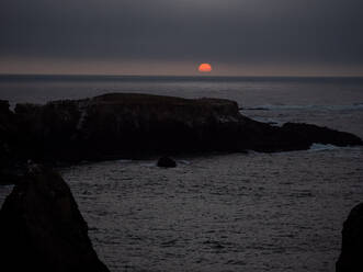 Orangefarbener Sonnenuntergang über der felsigen kalifornischen Küste - CAVF67071
