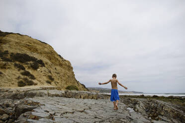 Rückansicht eines Jungen am Strand von Corona del Mar gegen den Himmel - CAVF67163