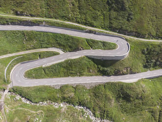 Vogelperspektive eines Radfahrers, der auf einer kurvenreichen Schweizer Landstraße fährt - CAVF67283