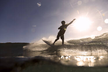 Surfer auf einer Welle bei Sonnenuntergang - CAVF67333