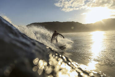 Surfer auf einer Welle bei Sonnenuntergang - CAVF67335