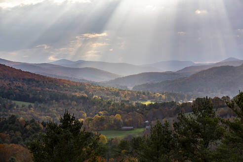 Das Sonnenlicht bricht durch die Wolken über den Bergen in Quechee, Vermont. - CAVF67373