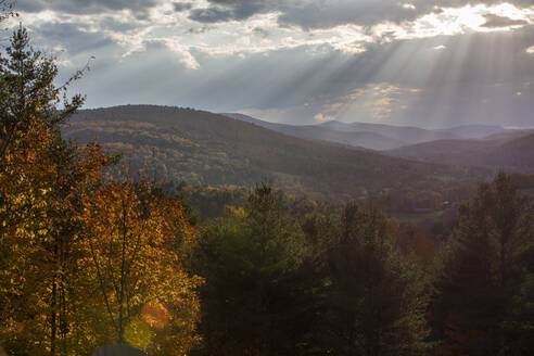 Das Sonnenlicht bricht durch die Wolken über den Bergen in Quechee, Vermont. - CAVF67374