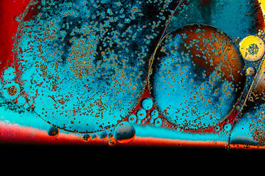 Macro shot of water oil emulsion over colored background - CAVF67389