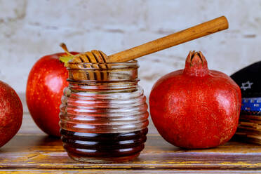 Gießen Honig auf Apfel und Granatapfel mit Honig Symbole der jüdischen Neujahr - Rosh Hashanah. - CAVF67403