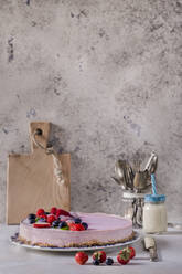 Erdbeerkäsekuchen in einem Teller auf einem Tisch an der Wand - CAVF67473