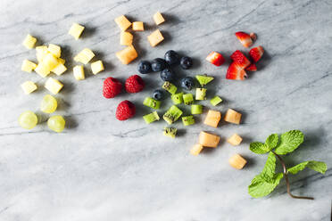 Overhead view of various fruit slices on marble counter - CAVF67574