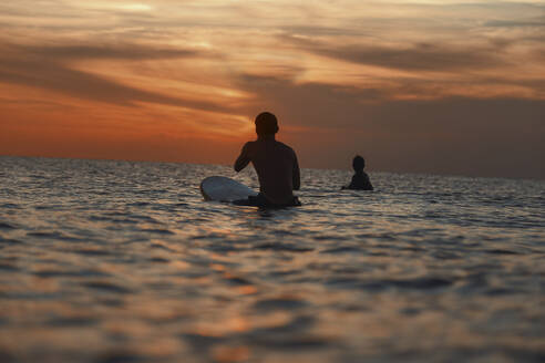 Zwei Surfer im Meer bei Sonnenuntergang - CAVF67616