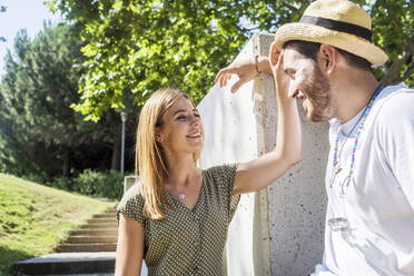 Lächelndes junges Paar flirtet in einem Park - CAVF67634