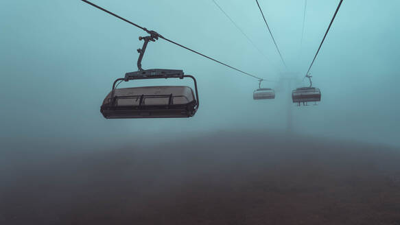 Unheimliche Seilbahn im dunklen Nebel - CAVF67639