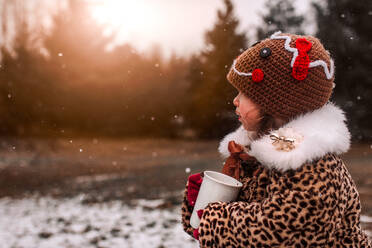 Little girl bundled up drinking hot chocolate on a cold winter day - CAVF67646