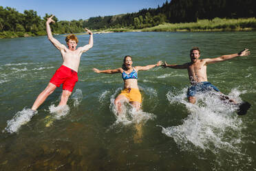 Friends jumping into lake - CAVF67681