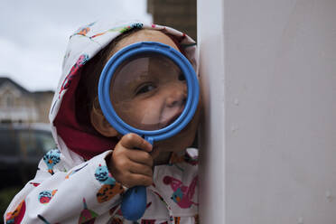 Portrait of girl holding magnifying glass - CAVF67701