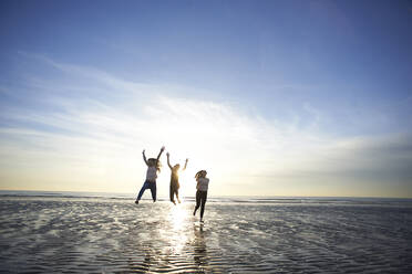 Female friends enjoying at beach against sky - CAVF67713