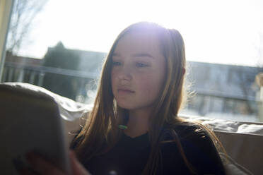 Teenage girl using tablet computer at home - CAVF67716