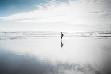 Rear view of woman walking at beach - CAVF67857