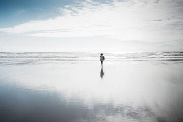 Rückansicht einer Frau, die am Strand spazieren geht - CAVF67857