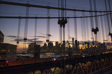 Cityscape against sky during sunset seen through Manhattan bridge - CAVF67879