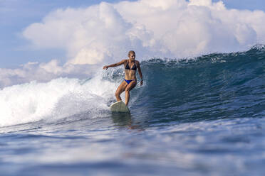Woman surfing in sea against sky - CAVF67888