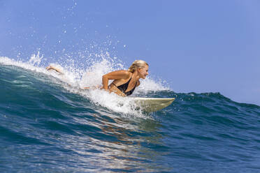 Selbstbewusste Frau beim Surfen im Meer gegen den Himmel - CAVF67891