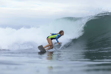 Side view of woman surfing on sea - CAVF67892