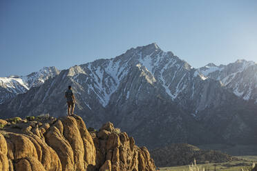 Wanderer in voller Länge mit Blick auf die Aussicht, während er auf einer Bergklippe steht - CAVF68011