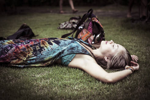 Seitenansicht einer im Gras schlafenden Frau - CAVF68036