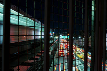 Blurred image of train on bridge over traffic at night - CAVF68039