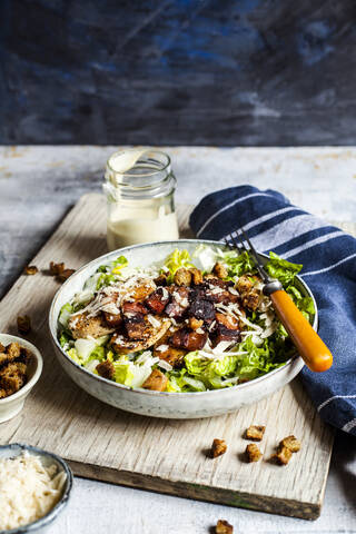 Schüssel Caesar-Salat mit Römersalat, Parmesankäse, Speck, Hähnchenbrust und Croutons, lizenzfreies Stockfoto