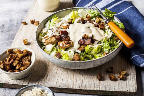 Bowl of Caesar salad with romaine lettuce, Parmesan cheese, bacon, chicken breast and croutons - SBDF04081