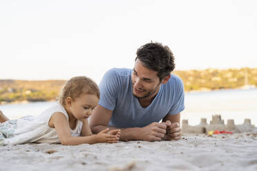 Vater und Tochter liegen am Strand - DIGF08755