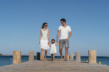 Familie beim Spaziergang auf einem Steg am Meer - DIGF08764