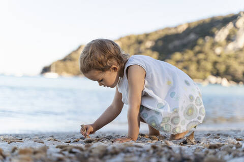 Niedliches Kleinkind Mädchen spielt am Strand, lizenzfreies Stockfoto