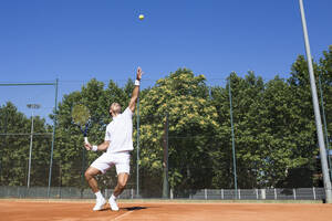 Tennisspieler, der einen Tennisball während eines Tennisspiels aufschlägt - ABZF02687