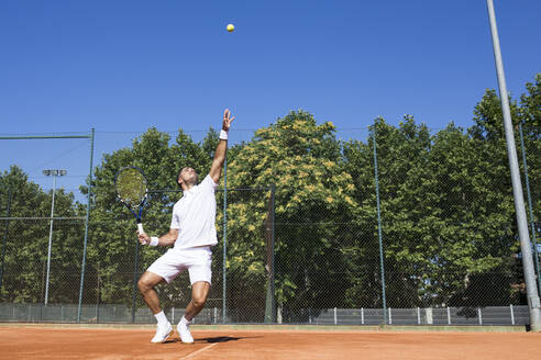 Tennisspieler, der einen Tennisball während eines Tennisspiels aufschlägt - ABZF02687