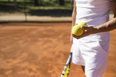 Mann hält Tennisbälle während eines Tennismatches - ABZF02695