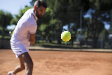 Tennis player during a tennis match, focus on tennis ball - ABZF02699