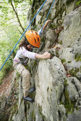 Mädchen mit Helm beim Klettern am Felsen in Lees Athas - CAVF68098