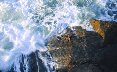 Hohe Winkel Ansicht der Wellen spritzen auf Felsen im Meer - CAVF68125