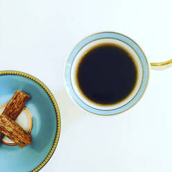 Overhead view of coffee cup and snacks on white table - CAVF68155