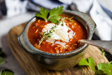 Schüssel mit verzehrfertiger Tomatensuppe mit saurer Sahne und Petersilie - SBDF04093