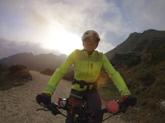 Senior man riding e-bike in nature - LAF02388