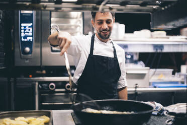 Cook at work in a restaurant kitchen - OCMF00857