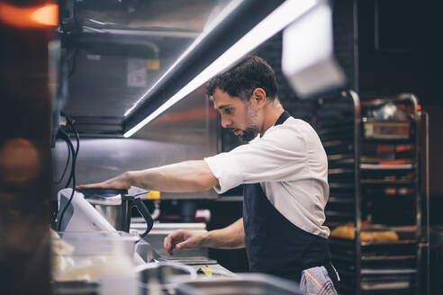 Cook at work in a restaurant kitchen - OCMF00860