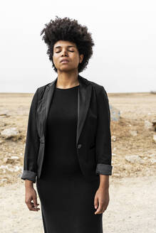 Porträt einer jungen, schwarz gekleideten Frau in einer düsteren Landschaft - ERRF01908