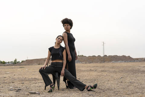 Porträt von zwei schwarz gekleideten Frauen in düsterer Landschaft, lizenzfreies Stockfoto